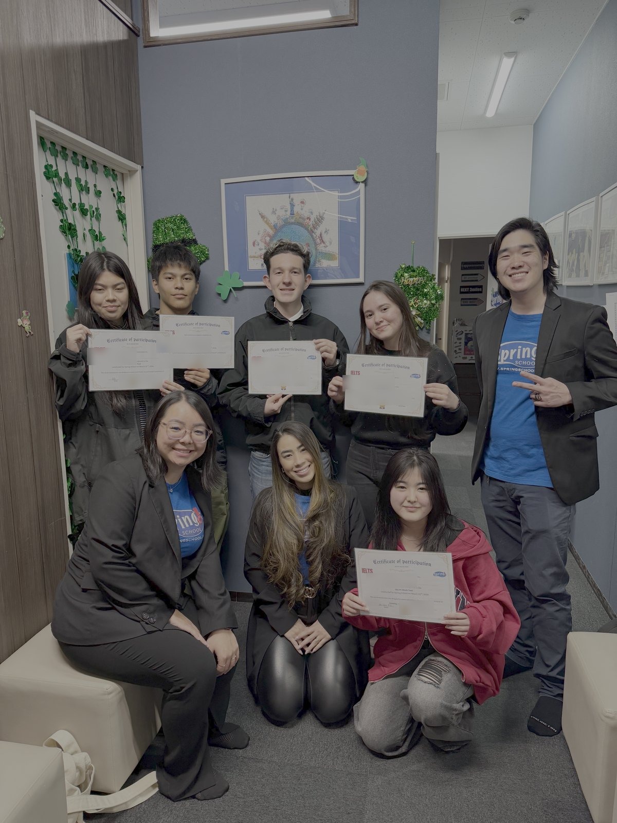 Grupo de alunos da Spring School exibindo seus certificados de IELTS