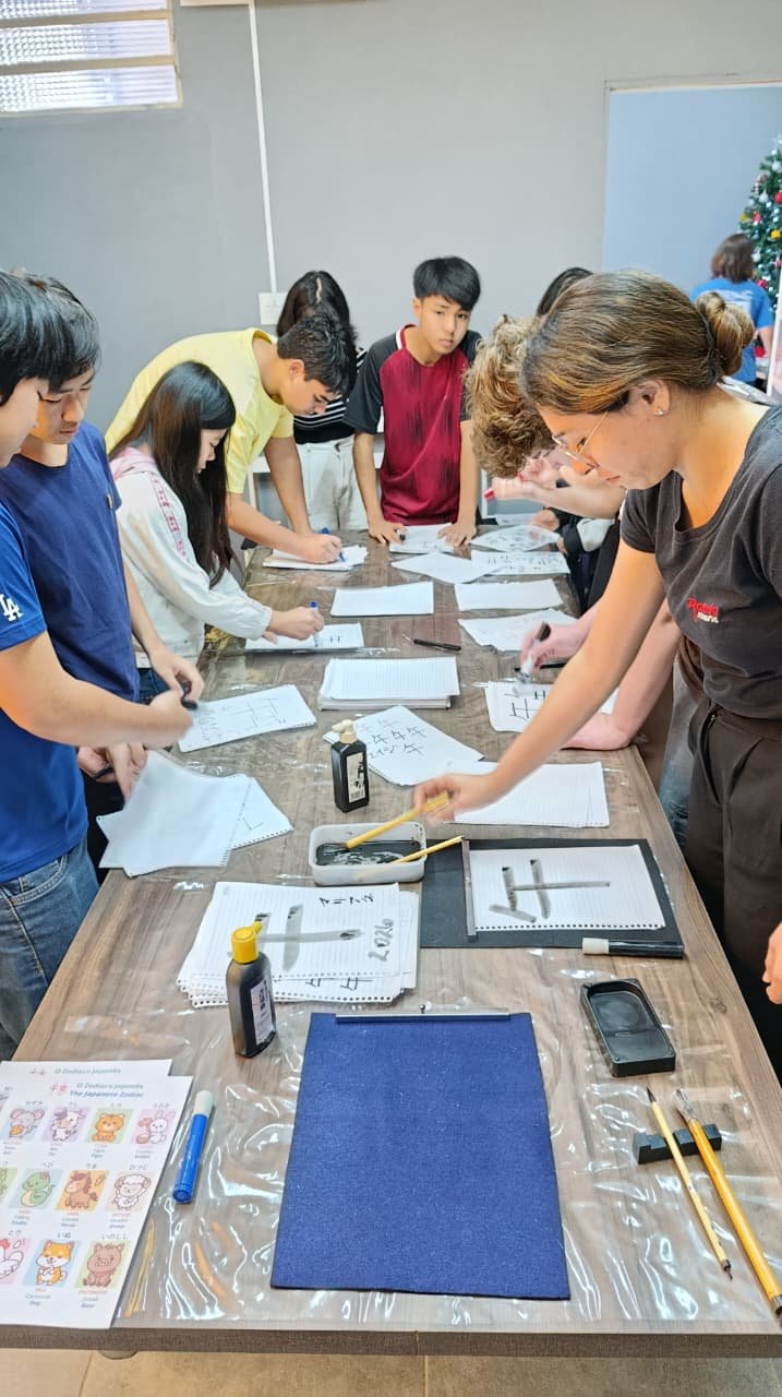 Alunos da Spring School Limeira praticando caligrafia japonesa, escrevendo kanji com pincel e nanquim